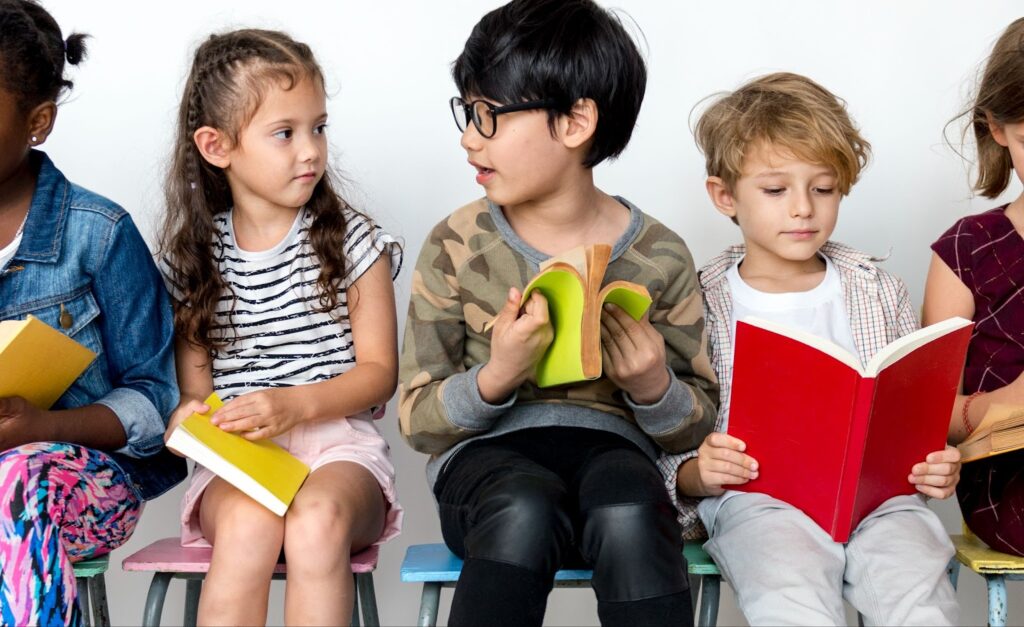 group of children sitting and reading a books